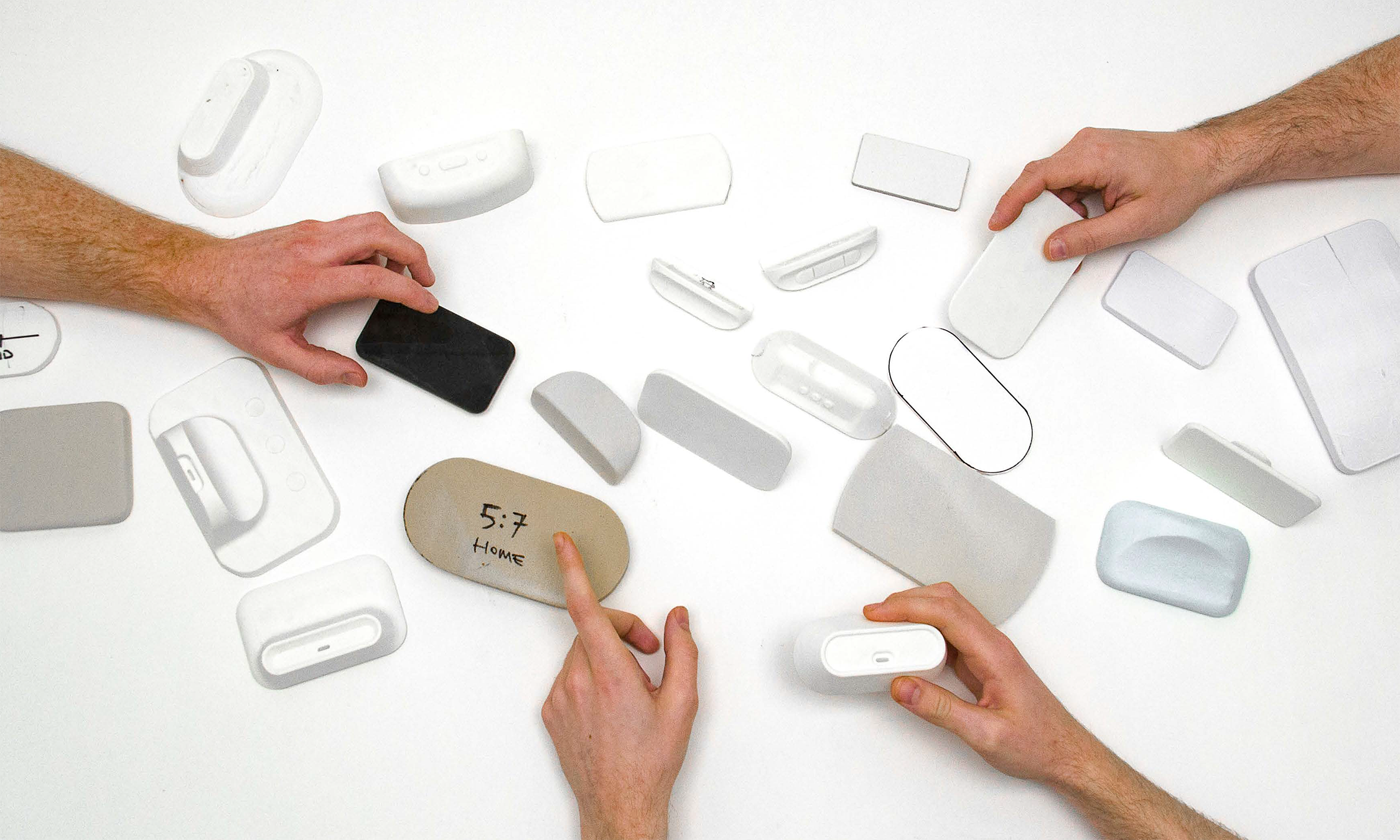 An overhead view of people pointing at different foam and plastic models for the large receivers.